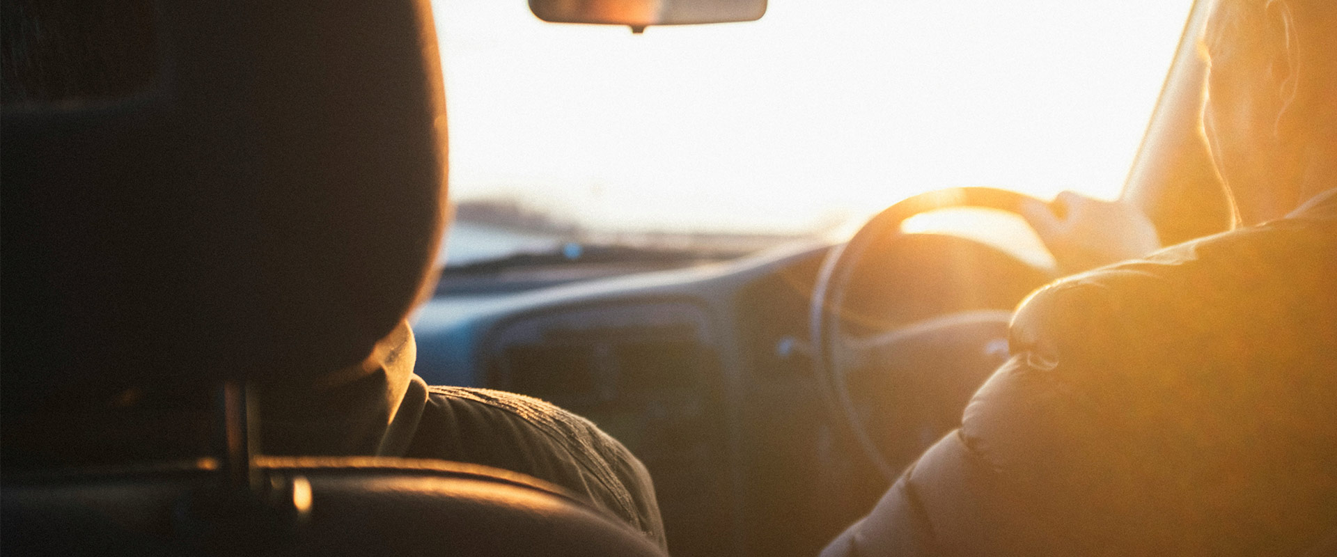View from the back seat looking forward in a right hand drive car at sunset