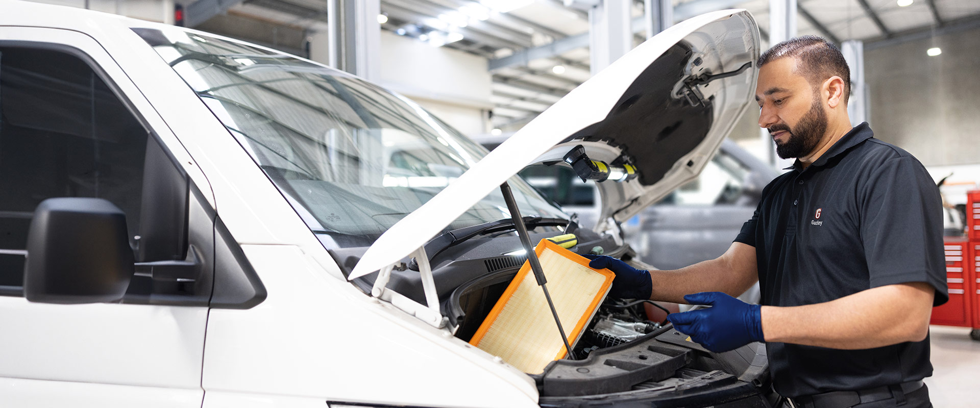 A Gazley technician working on a white VW van