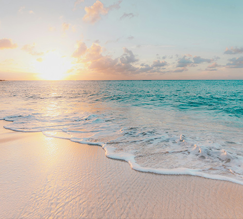 Photo of a beach with white sand during sunset